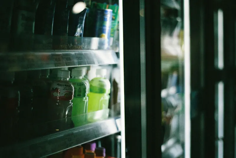 Close-up view of assorted drinks inside a refrigerated store display case