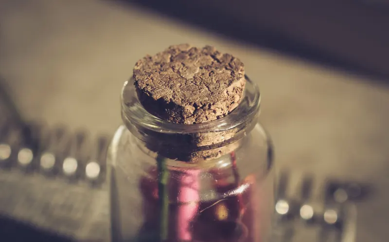 Close-up of a vintage glass jar with cork stopper, creating an earthy and artistic feel