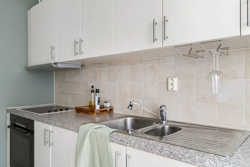 Sleek modern kitchen with granite countertops, stainless steel sink, and white cabinets