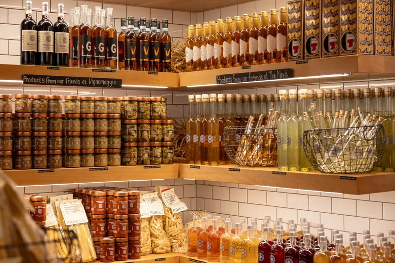 A vibrant display of Italian wines, spirits, and gourmet products in a rustic store setting